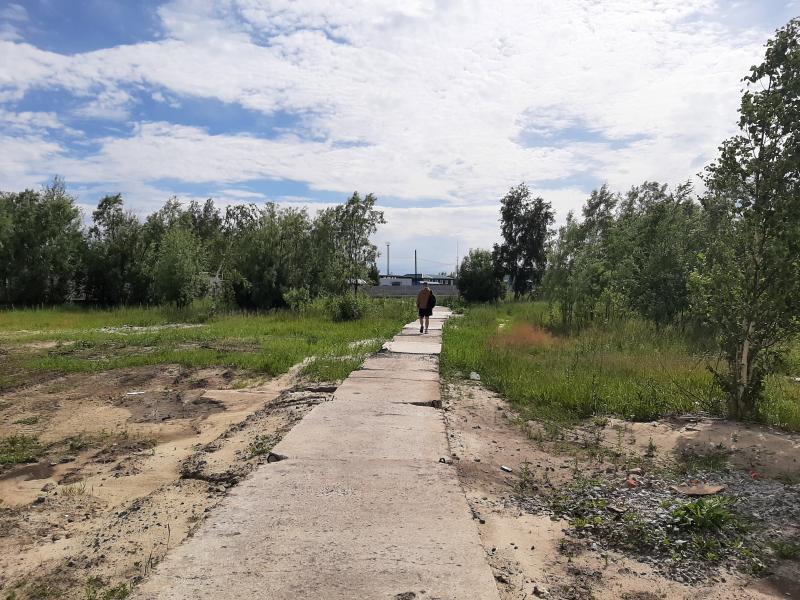 Тротуар из криво уложенных плит есть только на небольшом отрезке пути до действующей остановки. Фонарей на пустыре нет. Фото автора
